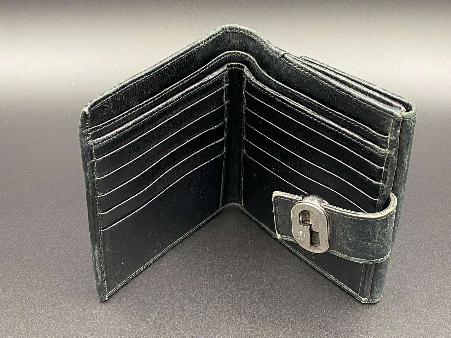 <p>GUCCI, &nbsp;a black, grained, leather wallet with signed and polished clasp</p>