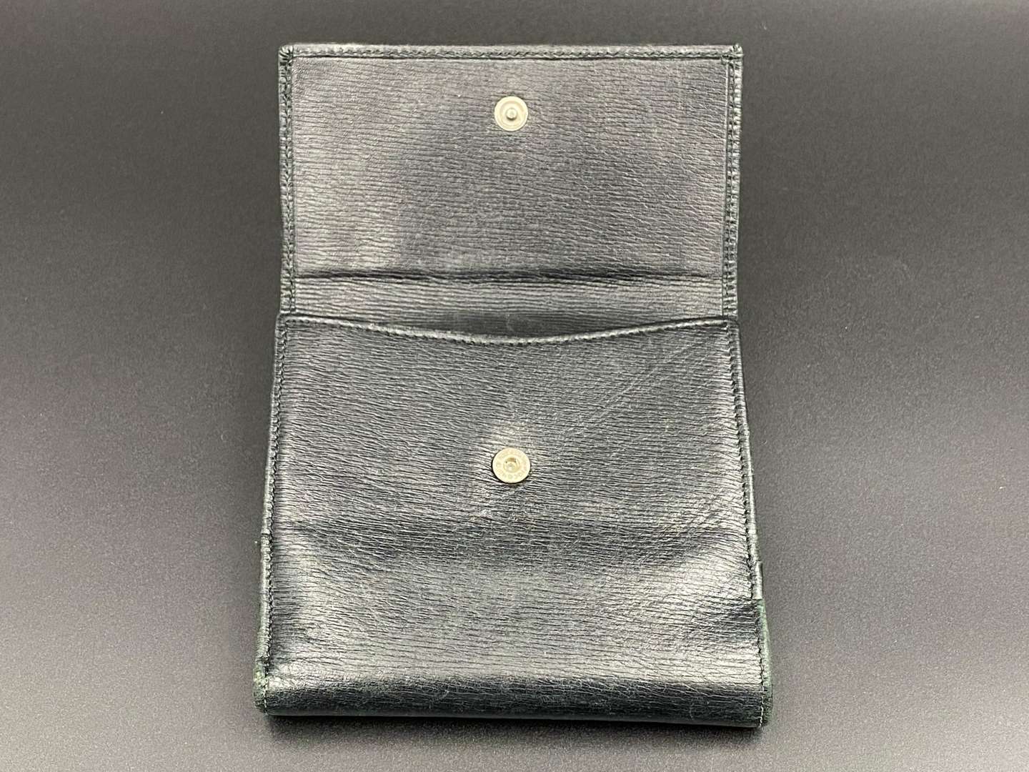 <p>GUCCI, &nbsp;a black, grained, leather wallet with signed and polished clasp</p>