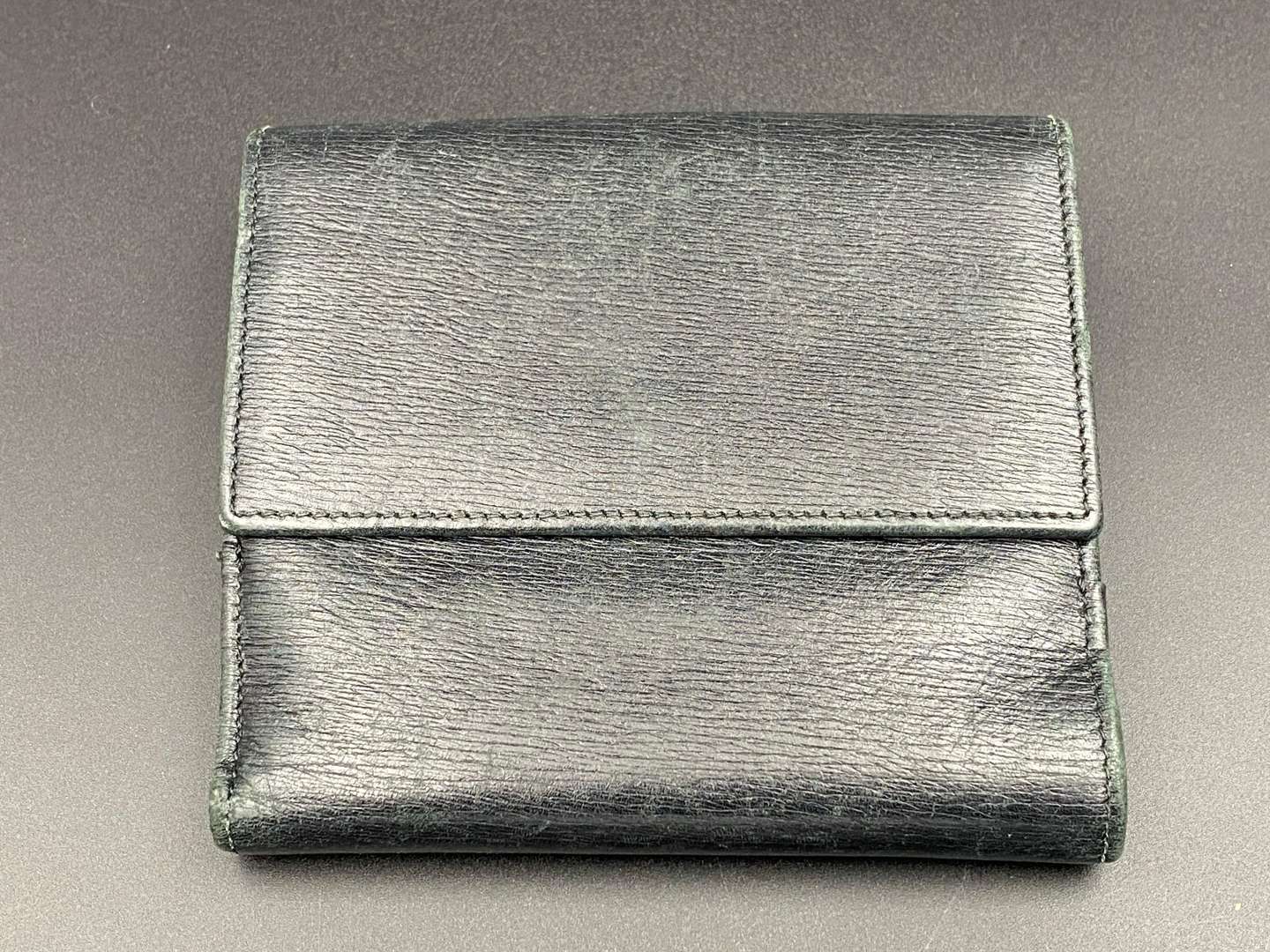 <p>GUCCI, &nbsp;a black, grained, leather wallet with signed and polished clasp</p>