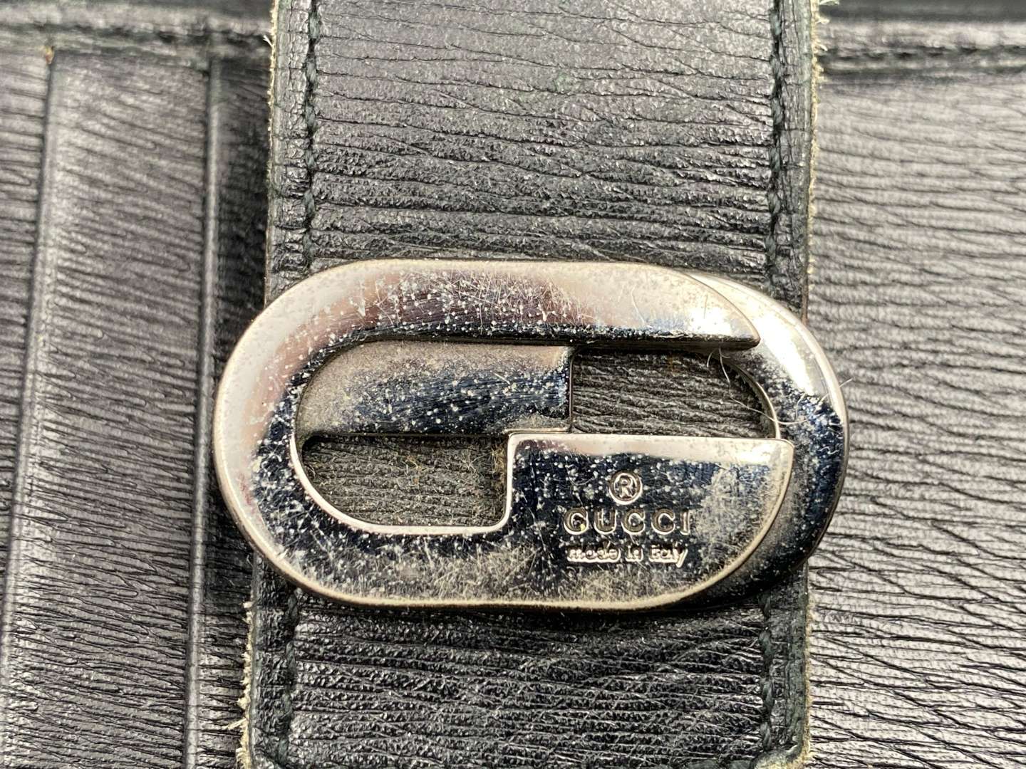 <p>GUCCI, &nbsp;a black, grained, leather wallet with signed and polished clasp</p>