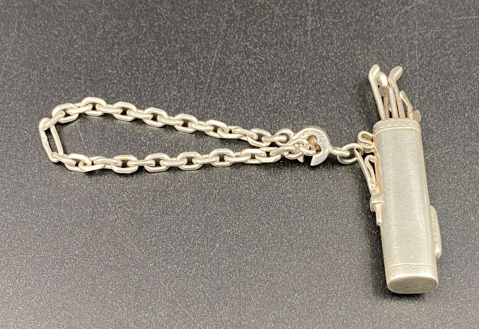 <p>A novelty white metal golf bag, button hole/ key chain,</p>