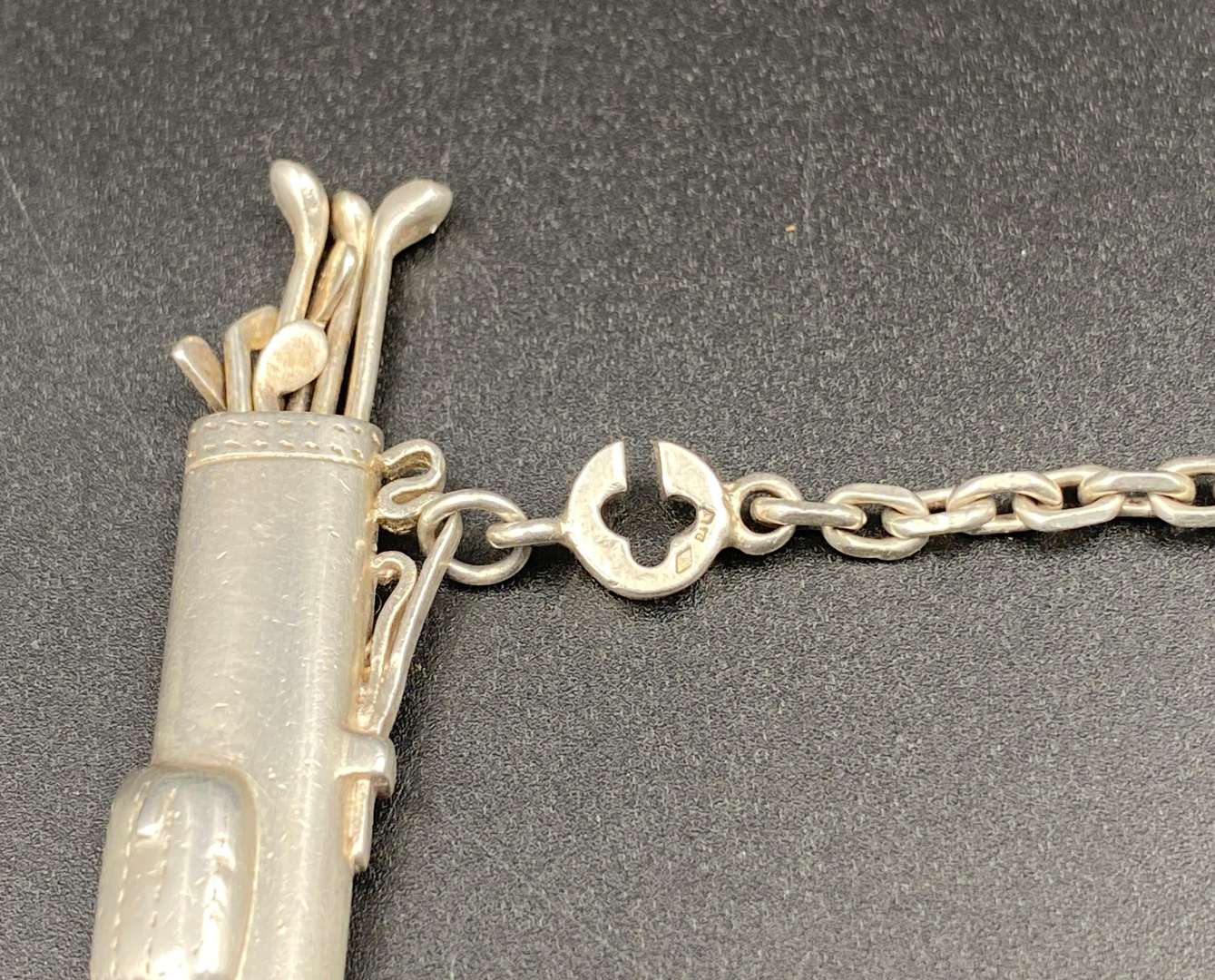 <p>A novelty white metal golf bag, button hole/ key chain,</p>