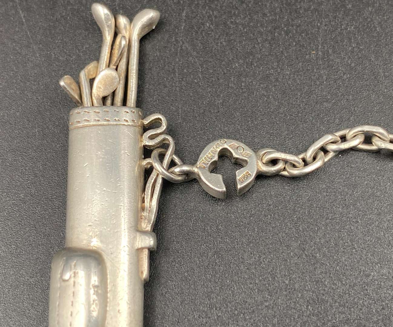 <p>A novelty white metal golf bag, button hole/ key chain,</p>