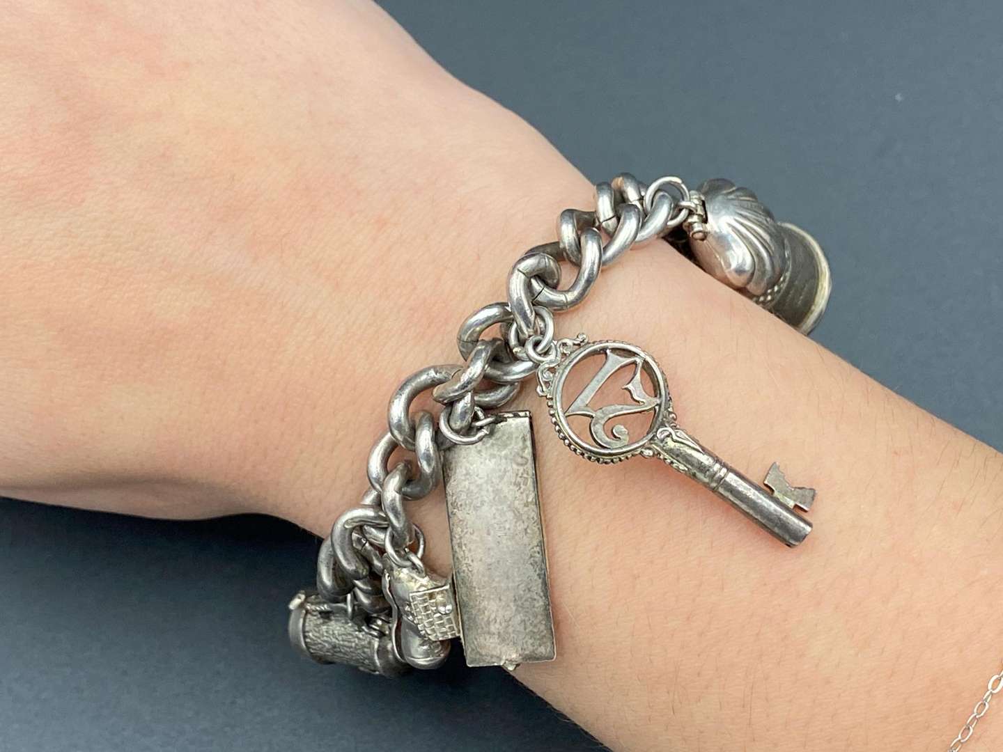 <p>A white metal charm bracelet,&nbsp;</p>