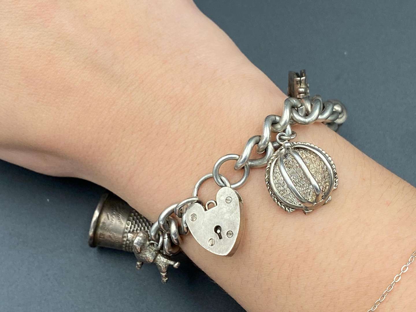 <p>A white metal charm bracelet,&nbsp;</p>