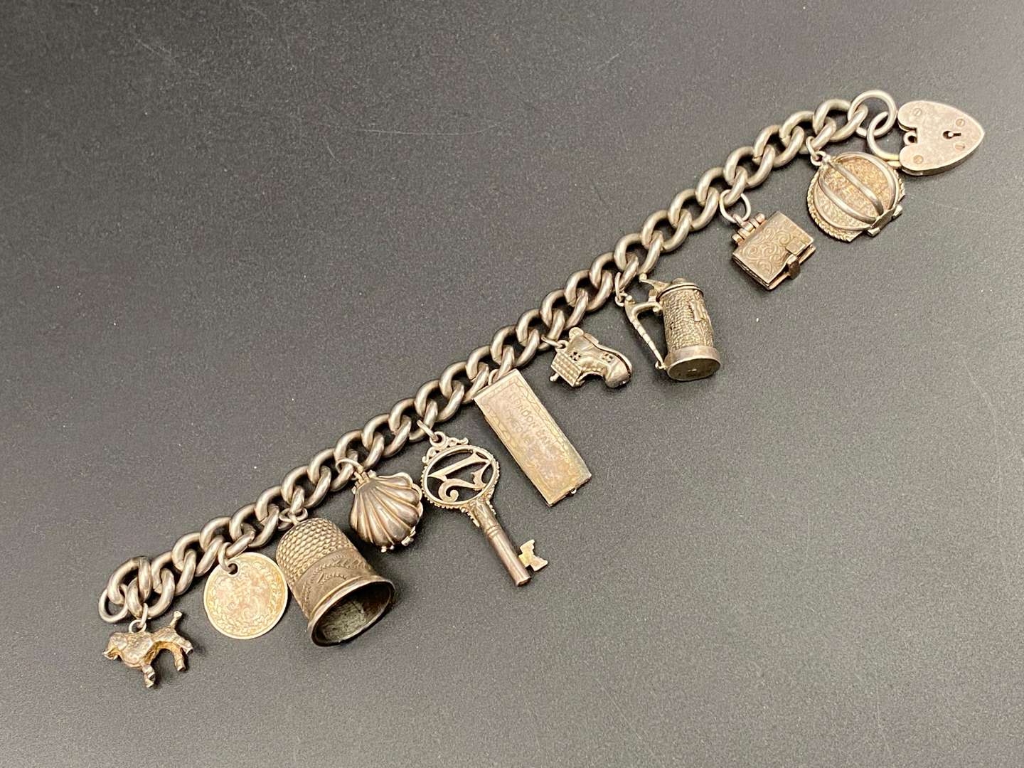 <p>A white metal charm bracelet,&nbsp;</p>