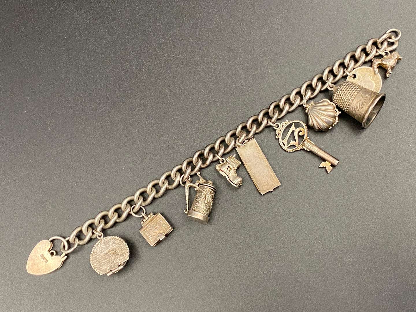 <p>A white metal charm bracelet,&nbsp;</p>