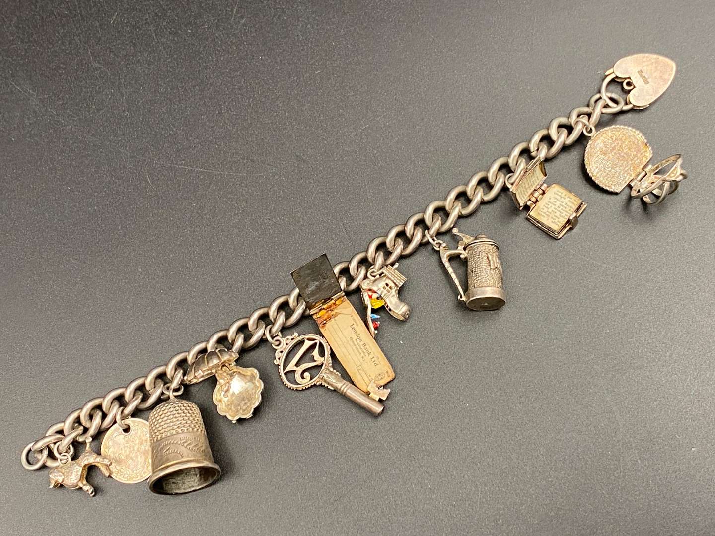 <p>A white metal charm bracelet,&nbsp;</p>