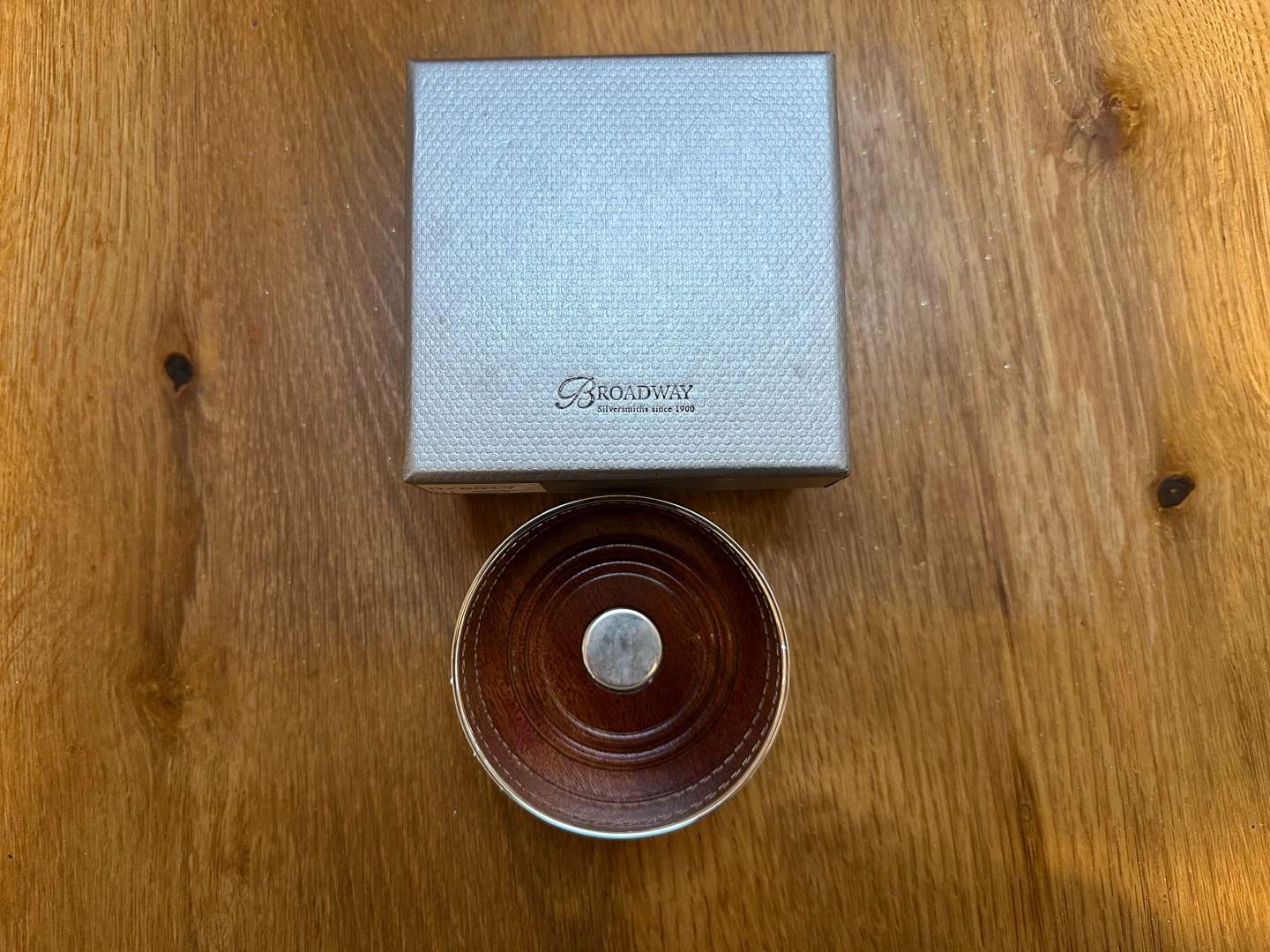 <p>BROADWAY & Co, an Elizabeth II hallmarked silver and mahogany bottle coaster&nbsp;</p>