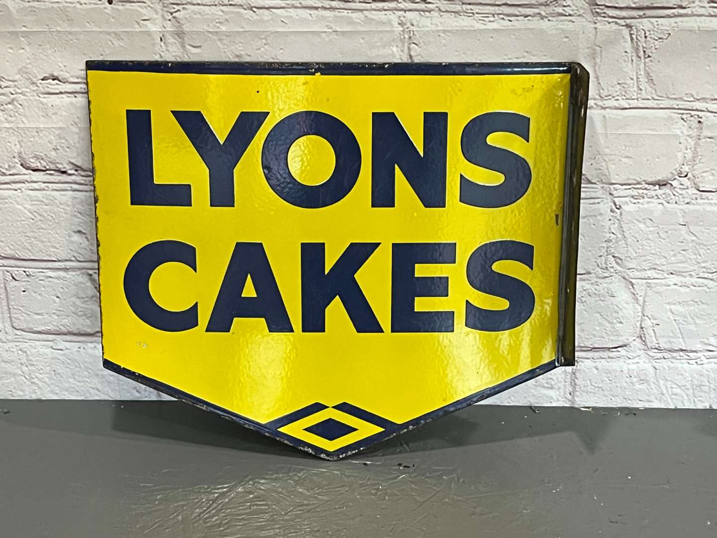 <p>Lyons Cakes Enamel Flange Sign</p>