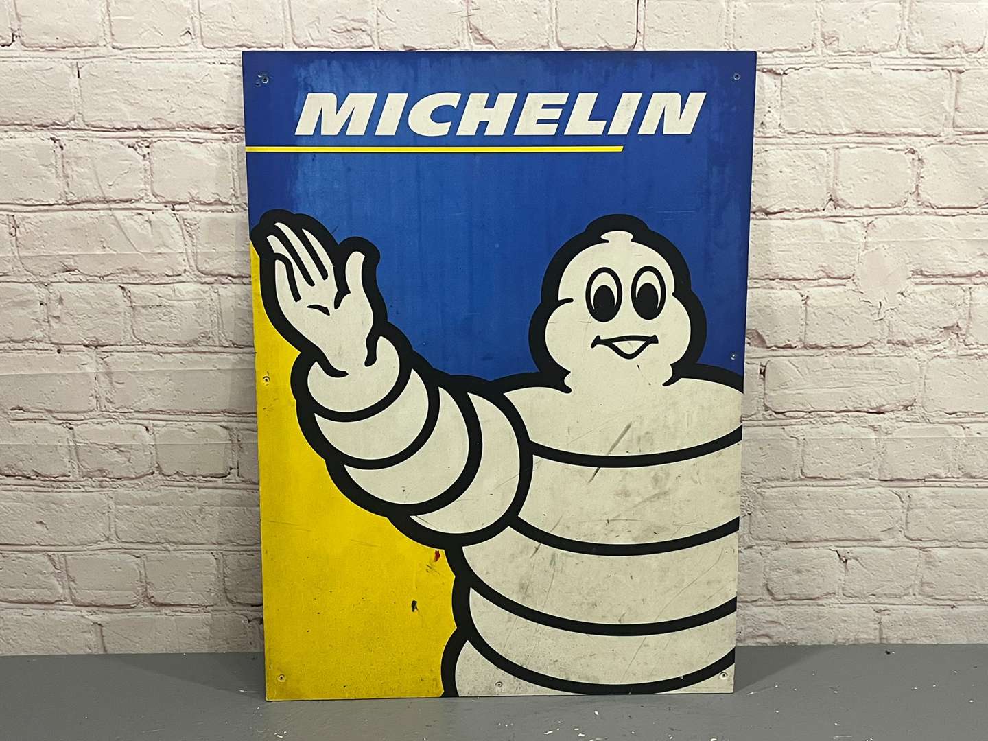 <p>Michelin Waving Man Sign on Board</p>