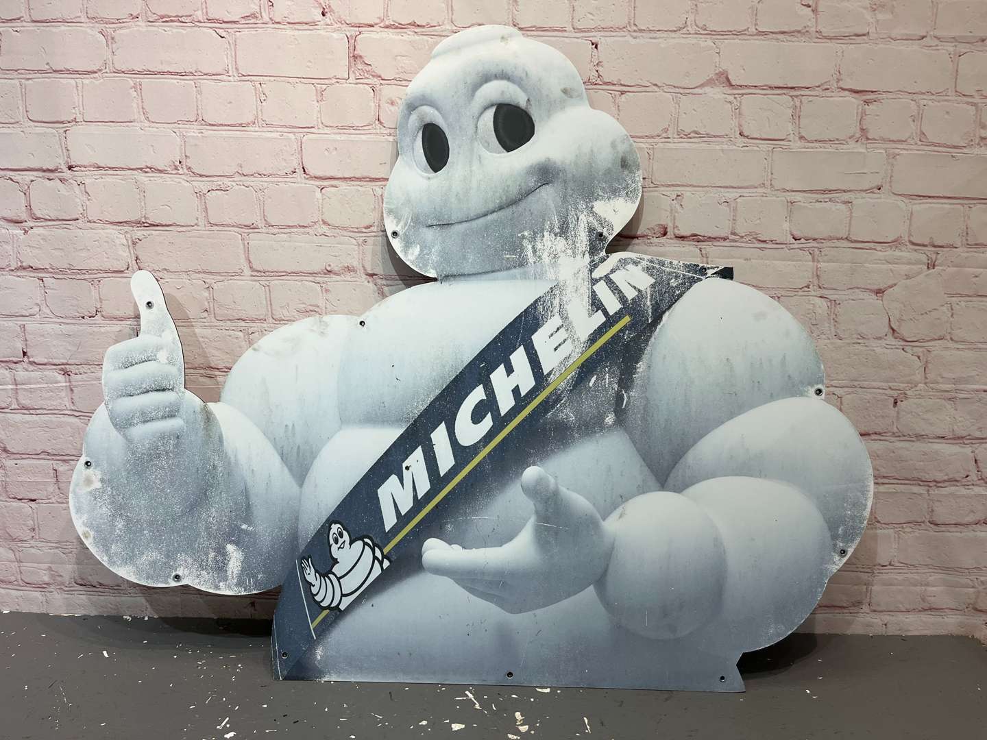<p>Large Michelin Man, Thumbs Up On Metal Board Sign</p>