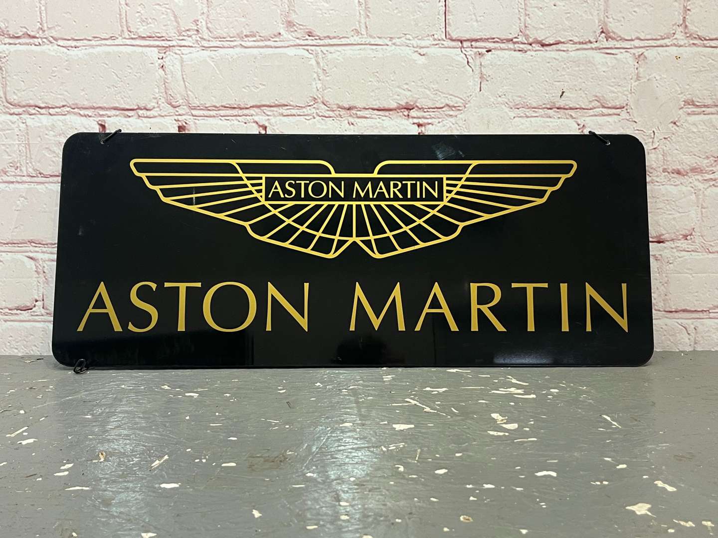 <p>Aston Martin Hanging Dealership Sign On Metal Board</p>